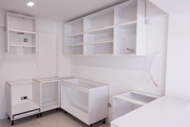 Ahşap dolapları olan lüks bir evde, güzel, parlak, temiz, bitmemiş bir mutfak üzerinde çalışmalar devam ediyor.