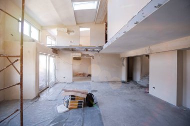 Büyük, modern, tamamlanmamış bir apartman dairesinde iskelesi olan inşaat sahasının içi.