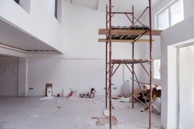 Büyük, modern, tamamlanmamış bir apartman dairesinde iskelesi olan inşaat sahasının içi.