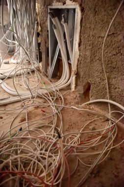 Duvarda kablolar olan kutular. Kablo arka plan. Duvardaki elektrik prizlerinden çıkan elektrik kabloları. Yeni elektrik kablosu kurulumu