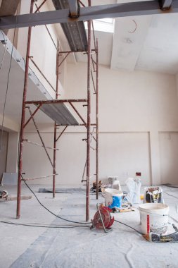 Büyük, modern, tamamlanmamış bir apartman dairesinde iskelesi olan inşaat sahasının içi.