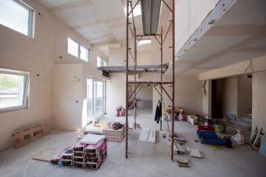 Büyük, modern, tamamlanmamış bir apartman dairesinde iskelesi olan inşaat sahasının içi.