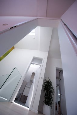 Halojen benekli lambalar ve çatı pencereleri olan bir ev ya da daireye bakıyordum. Gergin tavan beyaz ve karmaşık şekil