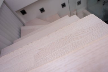 Büyük, modern, iki katlı lüks bir dairede ahşap merdivenleri olan şık bir iç mekan.