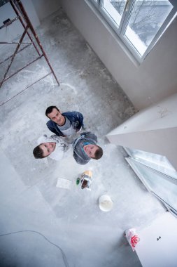 top view portrait of Workers and builders with dirty uniform in apartment that is under construction, remodeling,renovation,extension, restoration, overhaul and reconstruction clipart