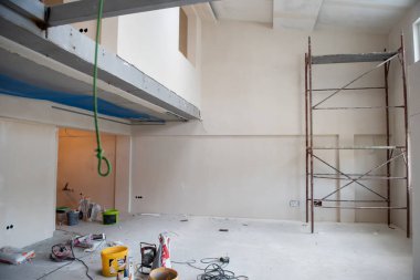 Büyük, modern, tamamlanmamış bir apartman dairesinde iskelesi olan inşaat sahasının içi.