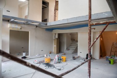 Büyük, modern, tamamlanmamış bir apartman dairesinde iskelesi olan inşaat sahasının içi.