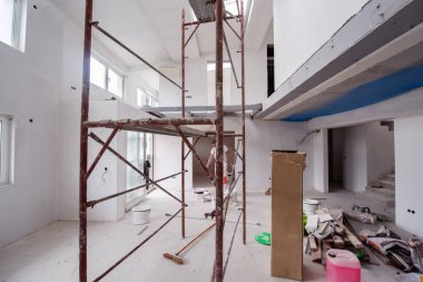 Büyük, modern, tamamlanmamış bir apartman dairesinde iskelesi olan inşaat sahasının içi.