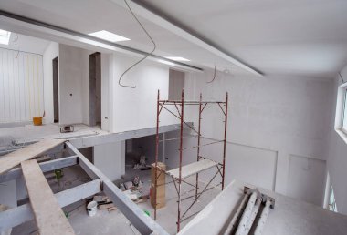 Büyük, modern, tamamlanmamış bir apartman dairesinde iskelesi olan inşaat sahasının içi.