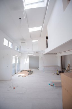 Tamamlanmamış, modern, iki katlı, beyaz duvarlı ve yakında taşınmaya hazır bir apartman dairesi.