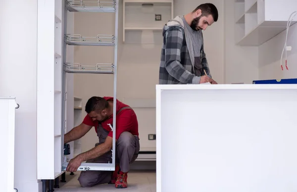 Два Профессиональных Работника Устанавливают Новую Стильную Современную Кухонную Мебель — стоковое фото