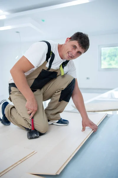 Profi Schreiner Mit Gummihammer Bei Der Verlegung Eines Neuen Laminatfußbodens — Stockfoto