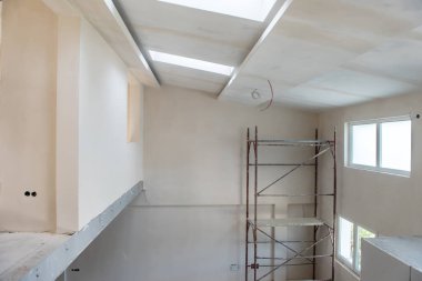 Büyük, modern, tamamlanmamış bir apartman dairesinde iskelesi olan inşaat sahasının içi.