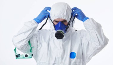 Koronavirüs 2019-nCoV küresel pandemik uyarı ve beyaz arka plana karşı tehlike arkaplanı nedeniyle koruyucu biyolojik giysi ve maske giyen doktor.