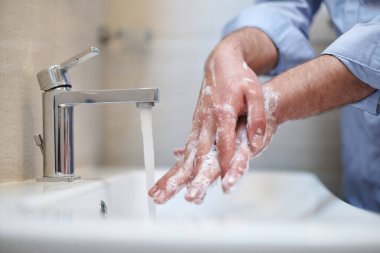 Coronavirus enfeksiyonu ve yayılan önleme sıvı sabunla düzgün yıkama elleri. Hijyen yanlısı erkek antibakteriyel eller banyoda yıkanır..