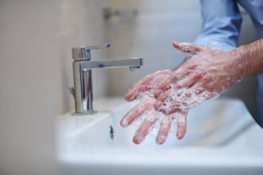 Coronavirus enfeksiyonu ve yayılan önleme sıvı sabunla düzgün yıkama elleri. Hijyen yanlısı erkek antibakteriyel eller banyoda yıkanır..