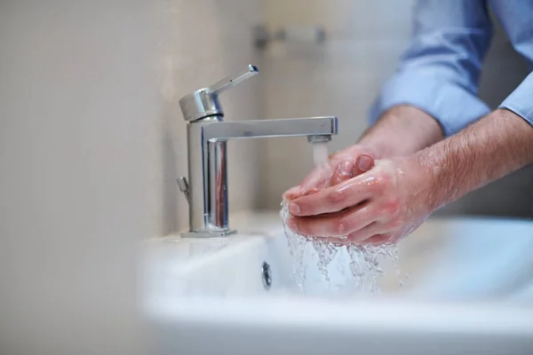 コロナウイルス感染症と拡散防止 液体石鹸で適切な手を洗う バスルームでの衛生的な男性抗菌手の水洗浄クローズアップ — ストック写真