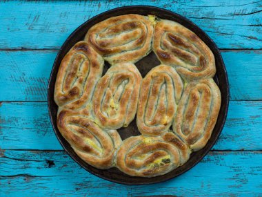 Kırsal ahşap ahşap arka planda burek turtası ve otantik çanak anten, üst görünüm düz plan