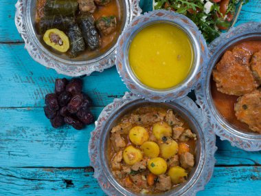 Bayram Mübarek Geleneksel Ramazan iftar yemeği. Ahşap mavi arka planda otantik kırsal tabaklarda çeşitli lezzetli yemekler. Bosna yemeği kebabı, pide, sarma, klepe, sogan dolma, kızarmış köfte. Ortadoğu tarihleri. Türk mutfağı. Üst v