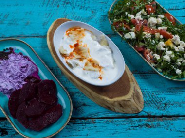 Bayram Mübarek Geleneksel Ramazan iftar yemeği. Ahşap mavi arka planda otantik kırsal tabaklarda çeşitli lezzetli yemekler. Bosna yemeği kebabı, pide, sarma, klepe, sogan dolma, kızarmış köfte. Ortadoğu tarihleri. Türk mutfağı. Üst v