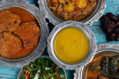 Bayram Mübarek Geleneksel Ramazan iftar yemeği. Ahşap mavi arka planda otantik kırsal tabaklarda çeşitli lezzetli yemekler. Bosna yemeği kebabı, pide, sarma, klepe, sogan dolma, kızarmış köfte. Ortadoğu tarihleri. Türk mutfağı. Üst v