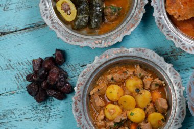 Bayram Mübarek Geleneksel Ramazan iftar yemeği. Ahşap mavi arka planda otantik kırsal tabaklarda çeşitli lezzetli yemekler. Bosna yemeği kebabı, pide, sarma, klepe, sogan dolma, kızarmış köfte. Ortadoğu tarihleri. Türk mutfağı. Üst v