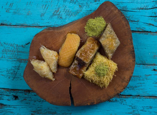 ラマダーン カレーム 伝統的なトルコの中東のイフタールのお菓子ピスタチオと新鮮な蜂蜜を素朴な木製のプレートとヴィンテージブルーの背景テーブルの上にバクラバ トップ表示 — ストック写真