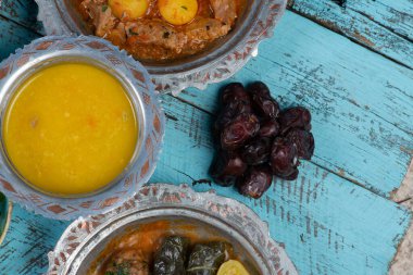 Bayram Mübarek Geleneksel Ramazan iftar yemeği. Ahşap mavi arka planda otantik kırsal tabaklarda çeşitli lezzetli yemekler. Bosna yemeği kebabı, pide, sarma, klepe, sogan dolma, kızarmış köfte. Ortadoğu tarihleri. Türk mutfağı. Üst v
