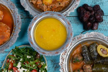 Bayram Mübarek Geleneksel Ramazan iftar yemeği. Ahşap mavi arka planda otantik kırsal tabaklarda çeşitli lezzetli yemekler. Bosna yemeği kebabı, pide, sarma, klepe, sogan dolma, kızarmış köfte. Ortadoğu tarihleri. Türk mutfağı. Üst v