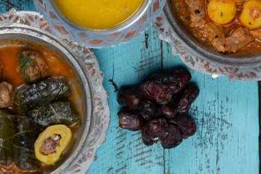 Bayram Mübarek Geleneksel Ramazan iftar yemeği. Ahşap mavi arka planda otantik kırsal tabaklarda çeşitli lezzetli yemekler. Bosna yemeği kebabı, pide, sarma, klepe, sogan dolma, kızarmış köfte. Ortadoğu tarihleri. Türk mutfağı. Üst v