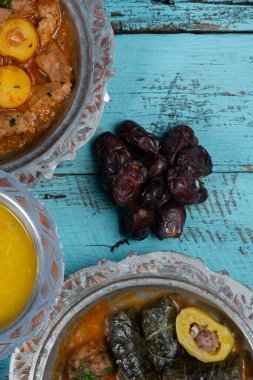 Bayram Mübarek Geleneksel Ramazan iftar yemeği. Ahşap mavi arka planda otantik kırsal tabaklarda çeşitli lezzetli yemekler. Bosna yemeği kebabı, pide, sarma, klepe, sogan dolma, kızarmış köfte. Ortadoğu tarihleri. Türk mutfağı. Üst v