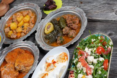 Bayram Mübarek Geleneksel Ramazan iftar yemeği. Ahşap mavi arka planda otantik kırsal tabaklarda çeşitli lezzetli yemekler. Bosna yemeği kebabı, pide, sarma, klepe, sogan dolma, kızarmış köfte. Ortadoğu tarihleri. Türk mutfağı. Üst v