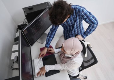 Girişim işi, genç yaratıcı profesyoneller insanlar parlak ofiste buluşmayı tartışırken öneriler ve projede yardım için çift ekran bilgisayarına işaret ediyorlar.
