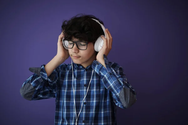 青少年戴耳机 聆听音乐及紫色背景 — 图库照片