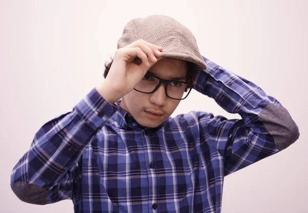 Gündelik okulda şapka takan zeki görünümlü Arap ergenin portresi beyaz fotokopi alanında izole görünüyor.