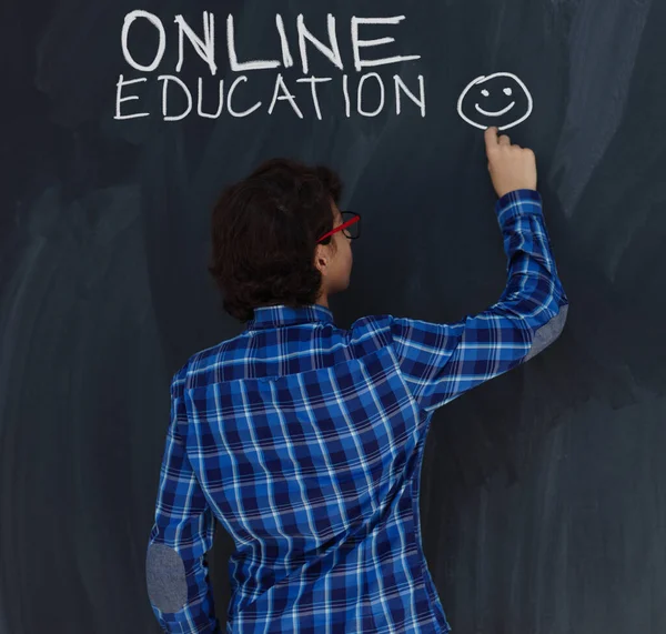 stock image Smart  Teen Boy writing with chalk  online education  on  black board in school coronavirus stay at home concept