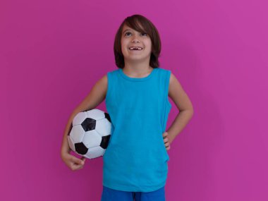 Pembe arka plan ve fotokopi alanına izole edilmiş futbol toplu genç Arap çocuk portresi