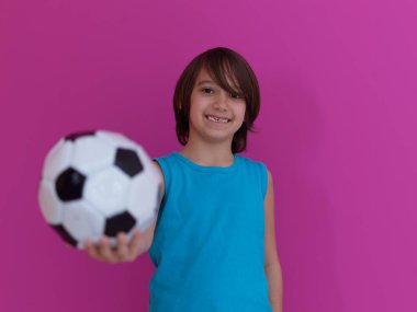 Pembe arka plan ve fotokopi alanına izole edilmiş futbol toplu genç Arap çocuk portresi