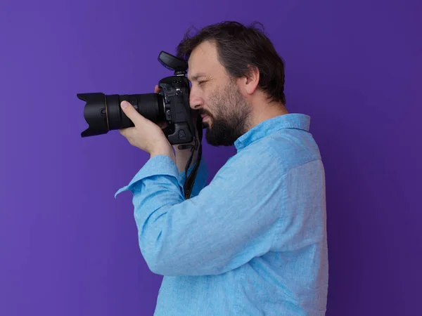 보라색 배경에 파란색 셔츠를 디지털 슬라이 카메라를 작가의 초상화 — 스톡 사진
