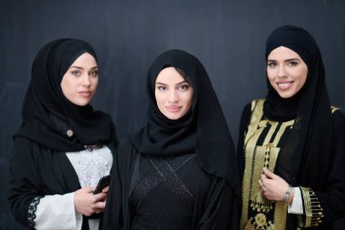 Modern İslami modayı ve Ramazan Kareem kavramını temsil eden siyah tesettürlü şık giyinmiş güzel Müslüman kadınların grup portresi.