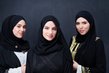 Modern İslami modayı ve Ramazan Kareem kavramını temsil eden siyah tesettürlü şık giyinmiş güzel Müslüman kadınların grup portresi.