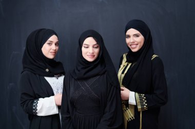 Modern İslami modayı ve Ramazan Kareem kavramını temsil eden siyah tesettürlü şık giyinmiş güzel Müslüman kadınların grup portresi.