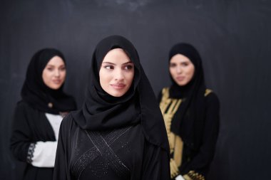Modern İslami modayı ve Ramazan Kareem kavramını temsil eden siyah tesettürlü şık giyinmiş güzel Müslüman kadınların grup portresi.