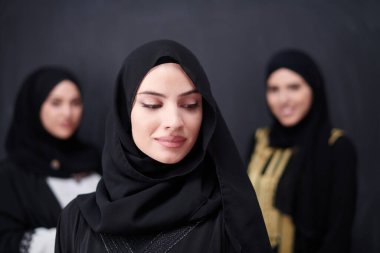 Modern İslami modayı ve Ramazan Kareem kavramını temsil eden siyah tesettürlü şık giyinmiş güzel Müslüman kadınların grup portresi.