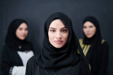 Modern İslami modayı ve Ramazan Kareem kavramını temsil eden siyah tesettürlü şık giyinmiş güzel Müslüman kadınların grup portresi.