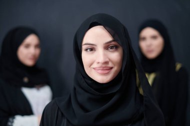 Modern İslami modayı ve Ramazan Kareem kavramını temsil eden siyah tesettürlü şık giyinmiş güzel Müslüman kadınların grup portresi.