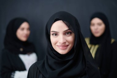 Modern İslami modayı ve Ramazan Kareem kavramını temsil eden siyah tesettürlü şık giyinmiş güzel Müslüman kadınların grup portresi.
