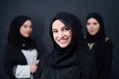 Modern İslami modayı ve Ramazan Kareem kavramını temsil eden siyah tesettürlü şık giyinmiş güzel Müslüman kadınların grup portresi.