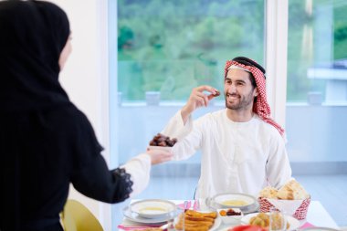 Mübarek Mübarek ailesi ziyafeti kırmak için akşam yemeği yiyor. Ramazan Bayramı 'nda evde geleneksel yemekler yemek. Modern Batı İslam 'da İslami helal yiyecekler ve içecekler.
