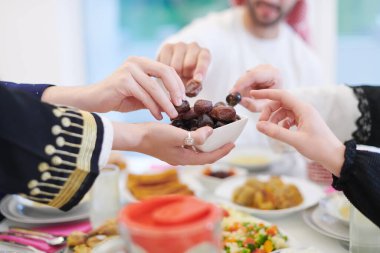 Mübarek Mübarek ailesi ziyafeti kırmak için akşam yemeği yiyor. Ramazan Bayramı 'nda evde geleneksel yemekler yemek. Modern Batı İslam 'da İslami helal yiyecekler ve içecekler.